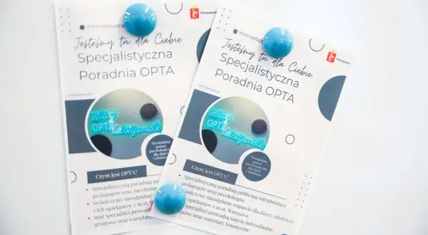 Dwie ulotki poradni OPTA z niebieskimi magnesami, na białym tle.