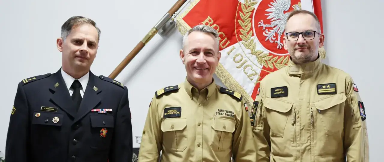 Komendant główny PSP Andrzej Bartkowiak z kolegami przed sztandarem.